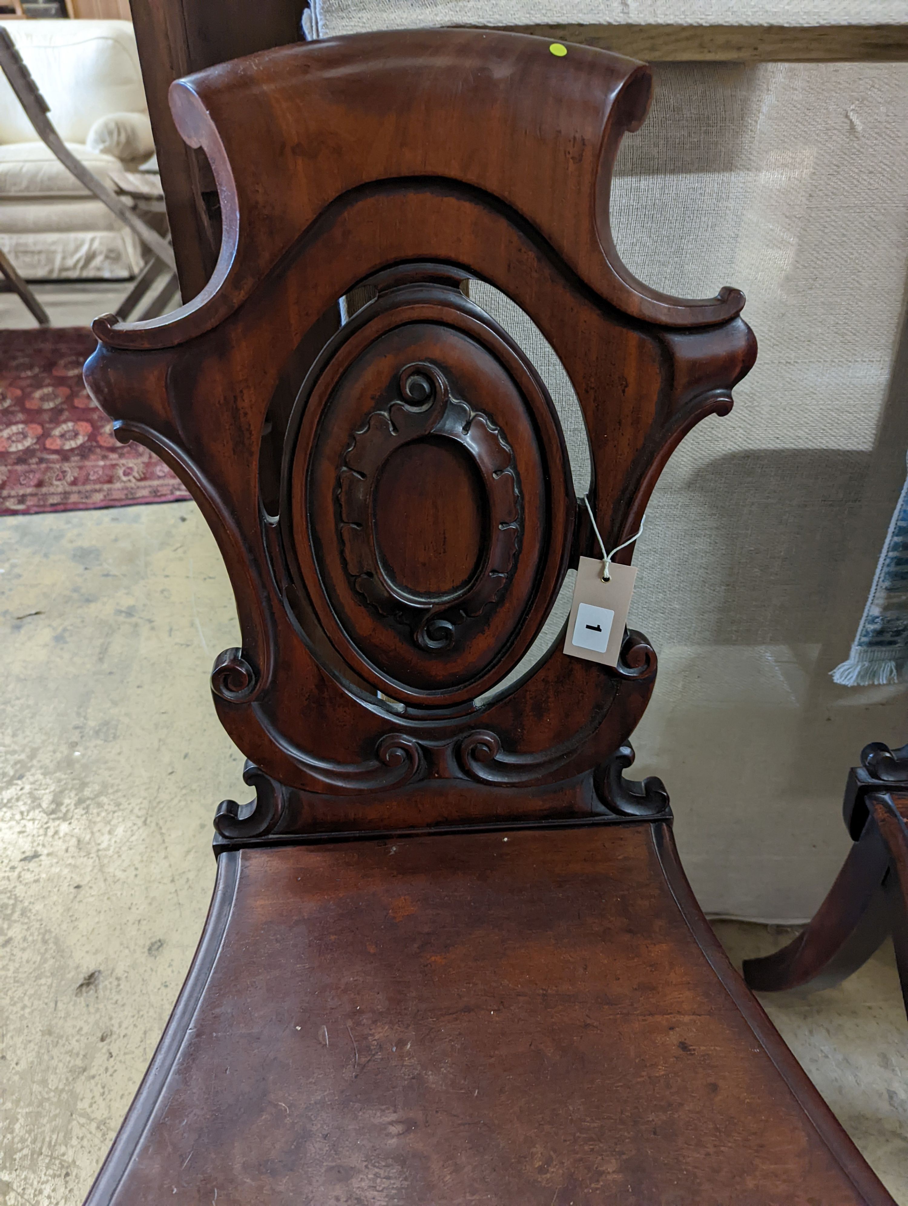 A pair of Victorian carved mahogany hall chairs, a.f.